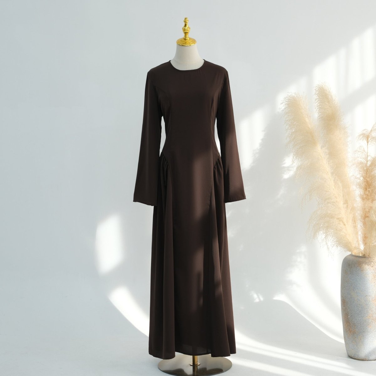 Draped bell sleeve detail showing full arm coverage on nida dress