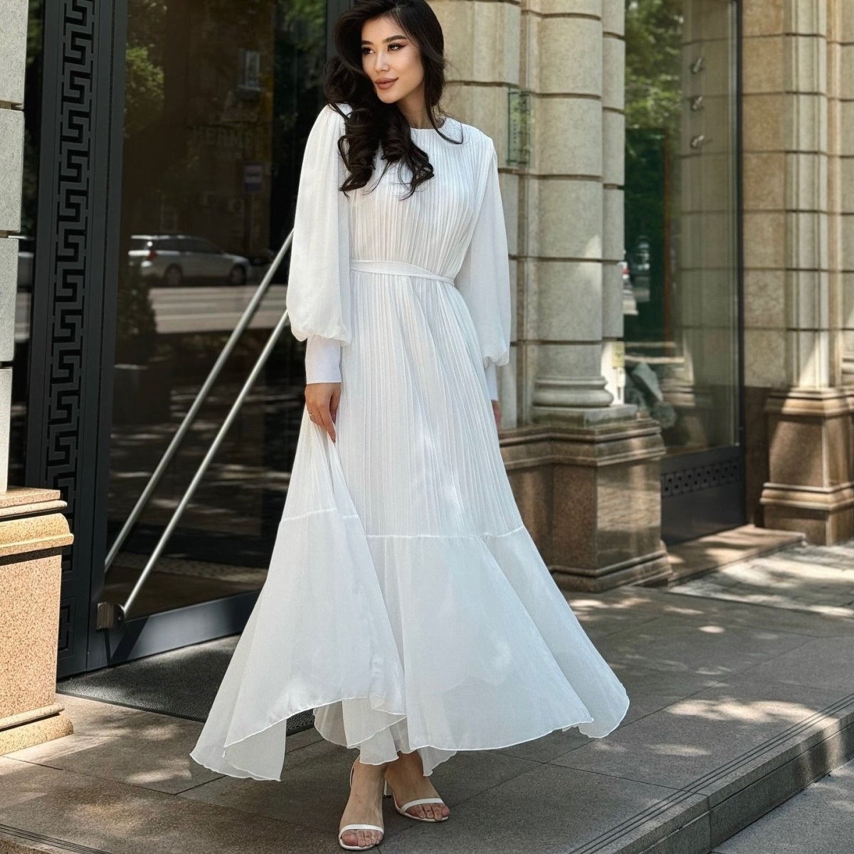 Overhead flat lay of pleated tiered maxi dress with belt accessory