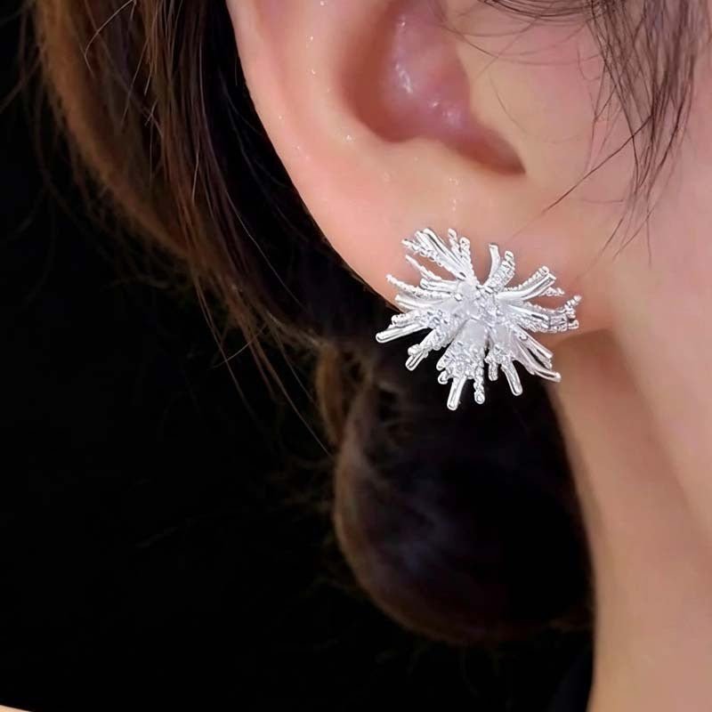 Close-up of multi-directional textured rays on crystal stud earrings