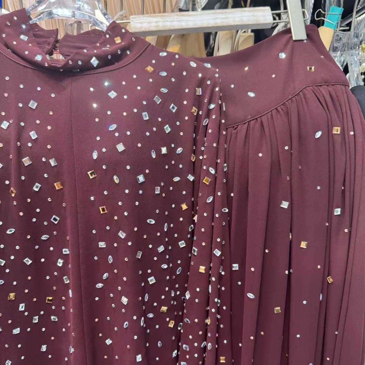 Close-up of scattered rhinestone confetti embellishments on shoulders and chest