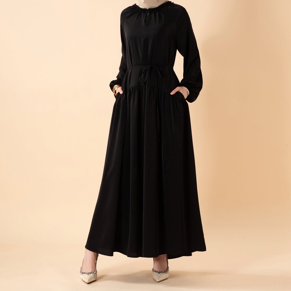 Side view showing fluid pleated skirt movement and relaxed silhouette