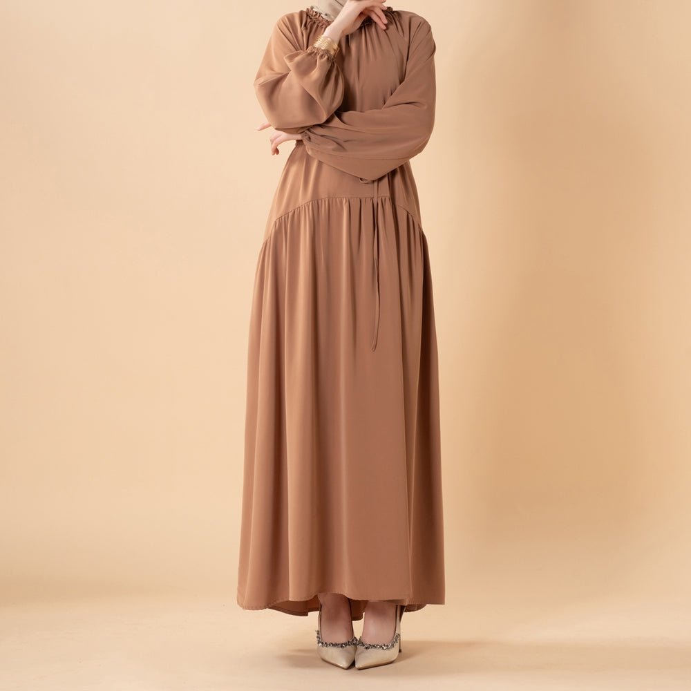 Pleated abaya styled with waist tie cinched for a defined silhouette