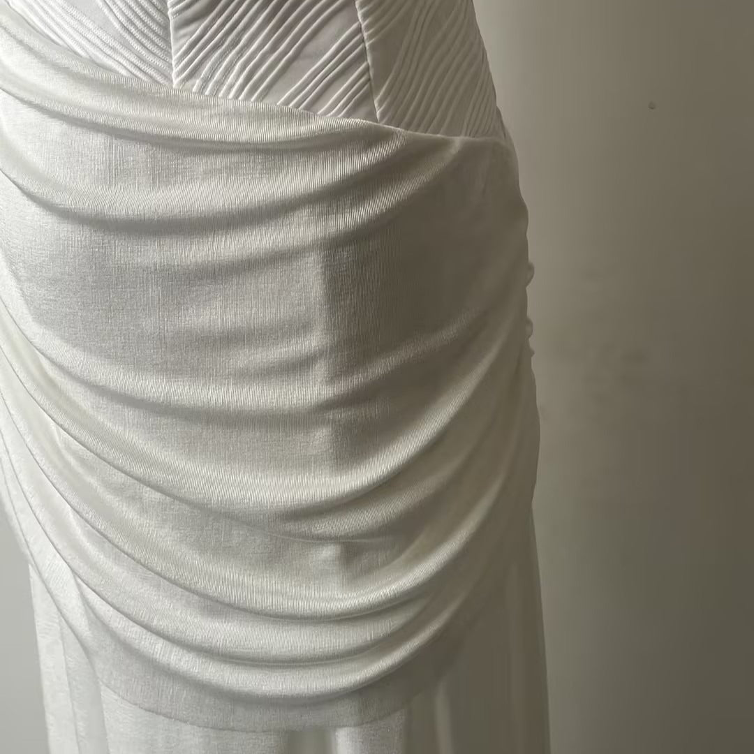 Full-length side view of white bodycon to maxi pleated gown for weddings and galas