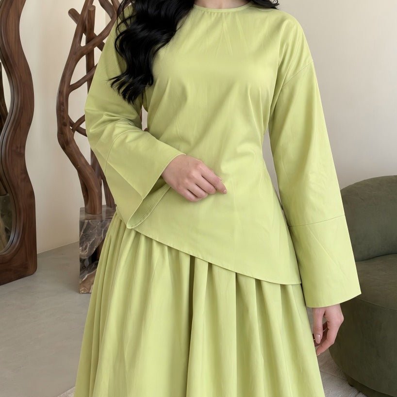 Solid colour top tucked into long maxi skirt for polished look