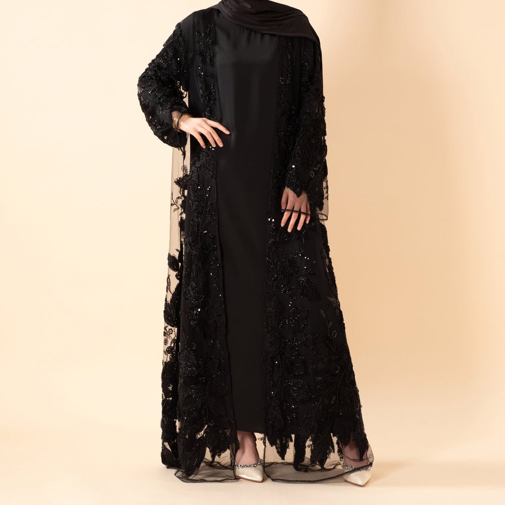 Flowing silhouette of couture open abaya against neutral background