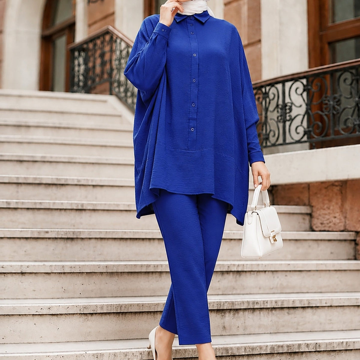 Batwing sleeve detail showing wide arc drape and rolled cuff finish