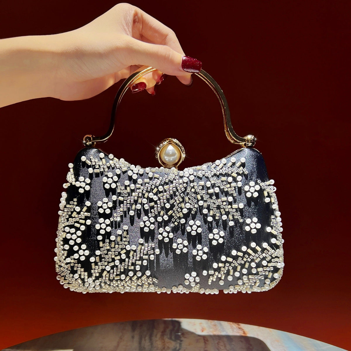 Structured metallic top handle detail of vintage pearl evening clutch