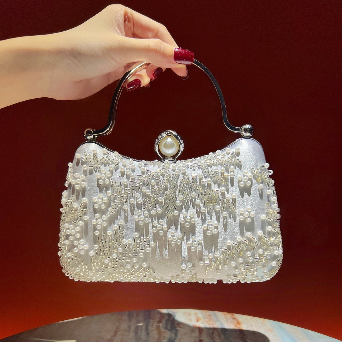 Close-up of rhinestone beading and faux pearl tassels on embroidered clutch purse