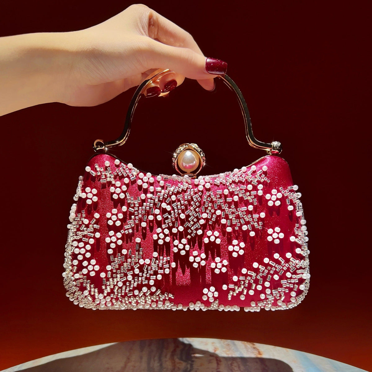 Pearl clasp closure detail on embroidered crossbody clutch bag