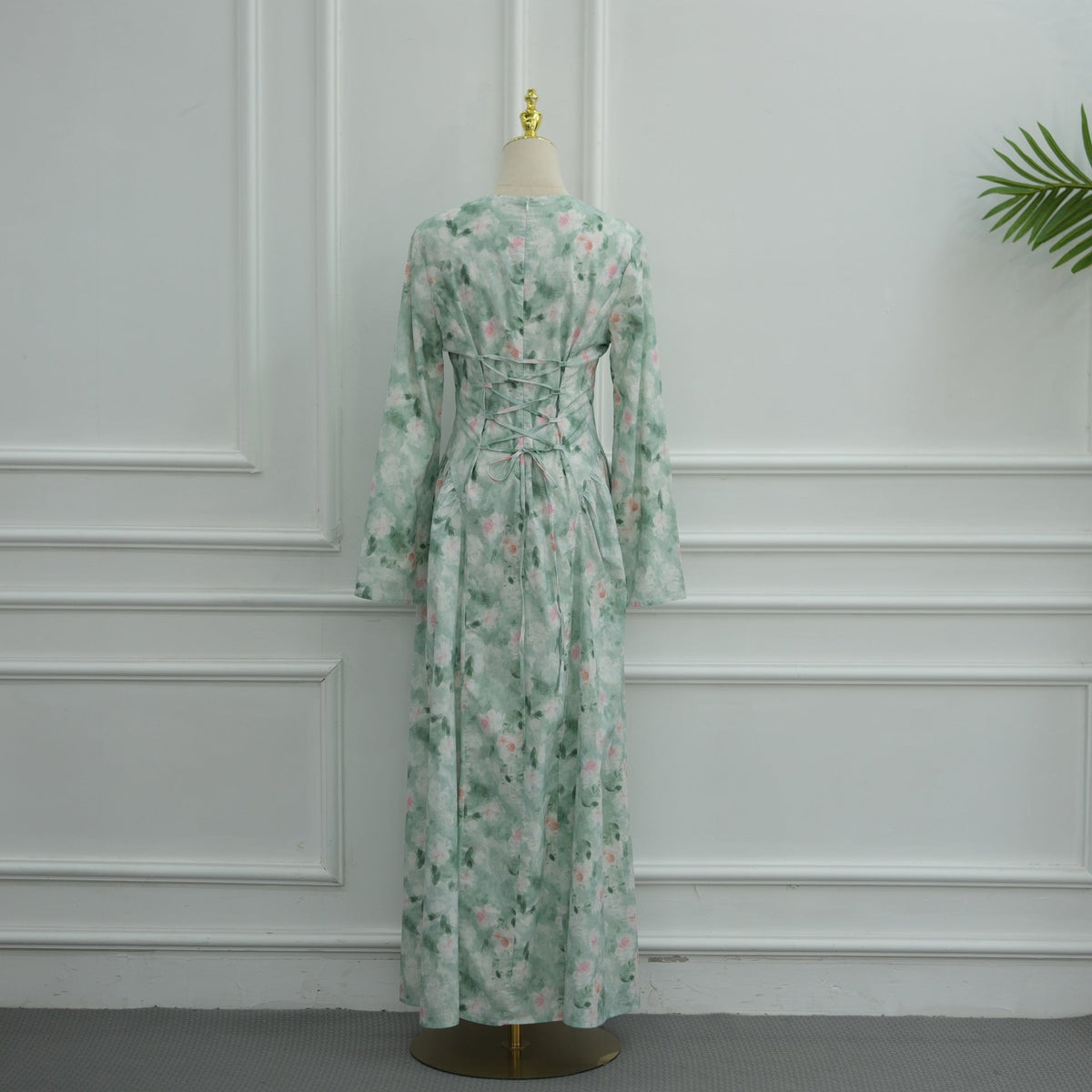 Wrist-level close-up of wide sweeping bell sleeve on floral maxi dress